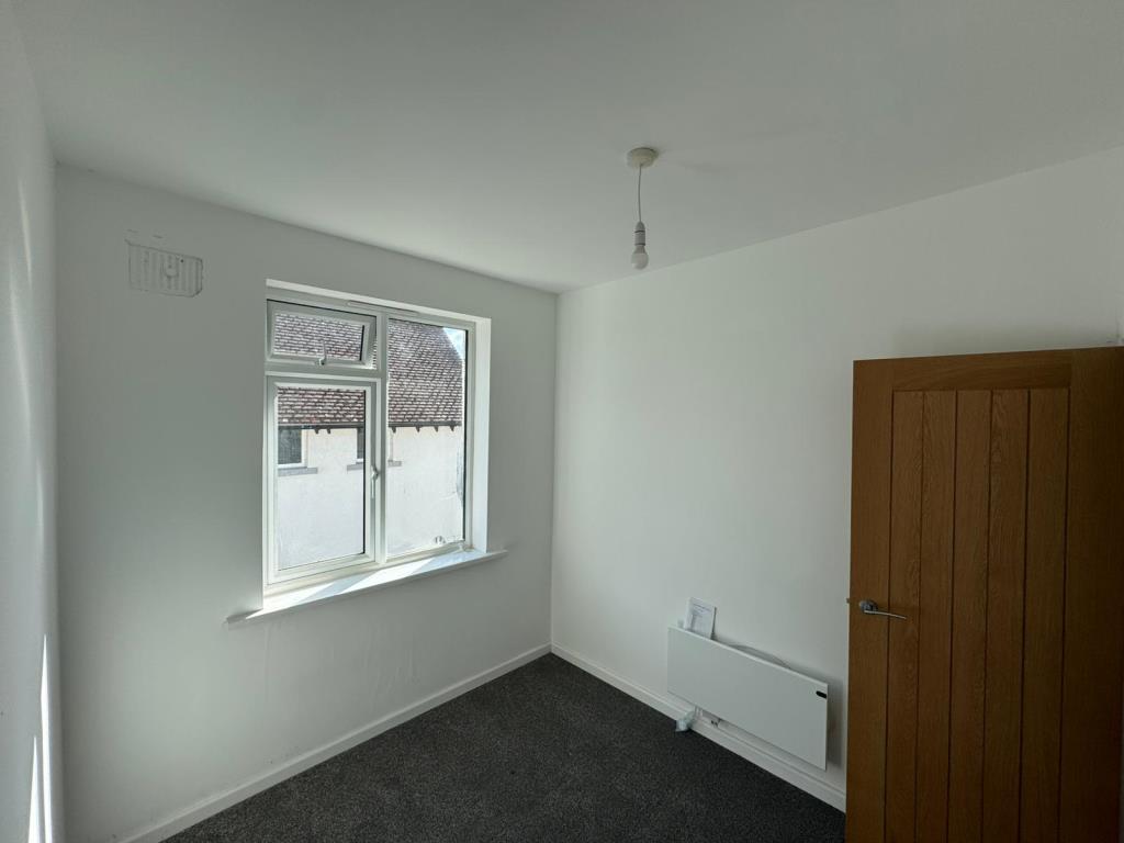 Lot: 58 - FREEHOLD TAKEAWAY UNIT WITH TWO-BEDROOM LIVING ACCOMMODATION - Bedroom two with white walls and grey carpet